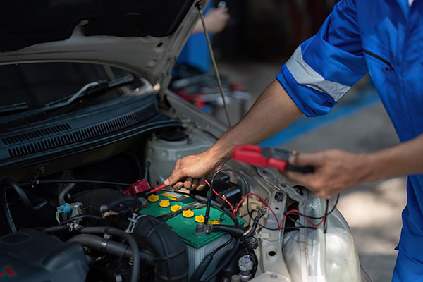 close up technician uses multimeter voltmeter to check car battery e car menlyn